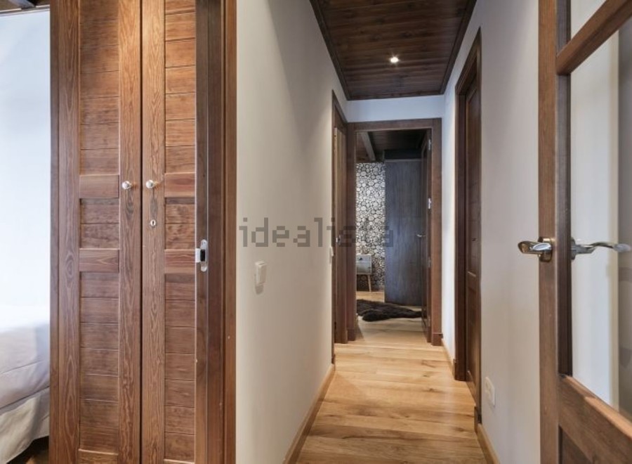 This stunning hallway boasts rich wooden flooring and doors, creating a warm and inviting atmosphere.