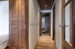 This stunning hallway boasts rich wooden flooring and doors, creating a warm and inviting atmosphere.