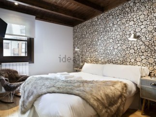 Cozy cabin bedroom with wood slice accent wall, plush fur throw, and comfortable rocking chair.