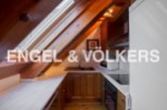 Charming attic kitchen with wooden beams and skylights.