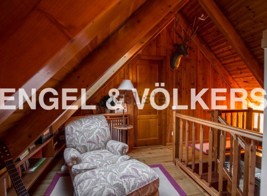 Cozy attic retreat with wood-paneled walls and charming reading nook.