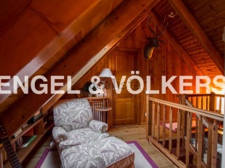 Cozy attic retreat with wood-paneled walls and charming reading nook.
