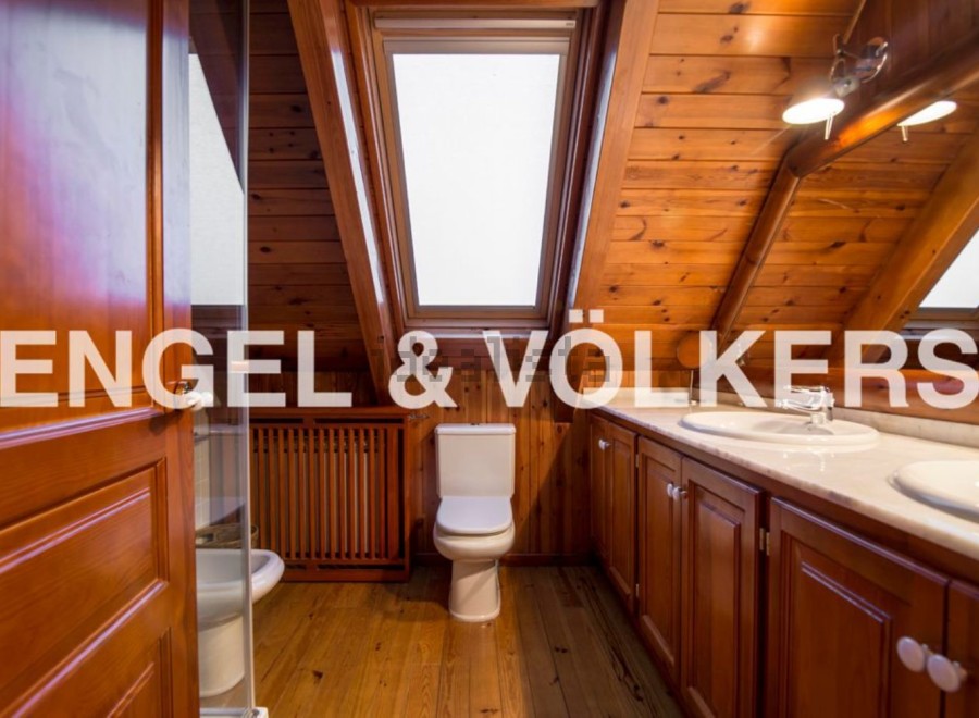 This stunning bathroom boasts a unique wooden design, complete with skylights that flood the space with natural light.