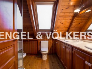 This stunning bathroom boasts a unique wooden design, complete with skylights that flood the space with natural light.