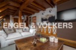 This stunning chalet boasts a spacious living area with exposed wooden beams, creating a warm and inviting atmosphere.