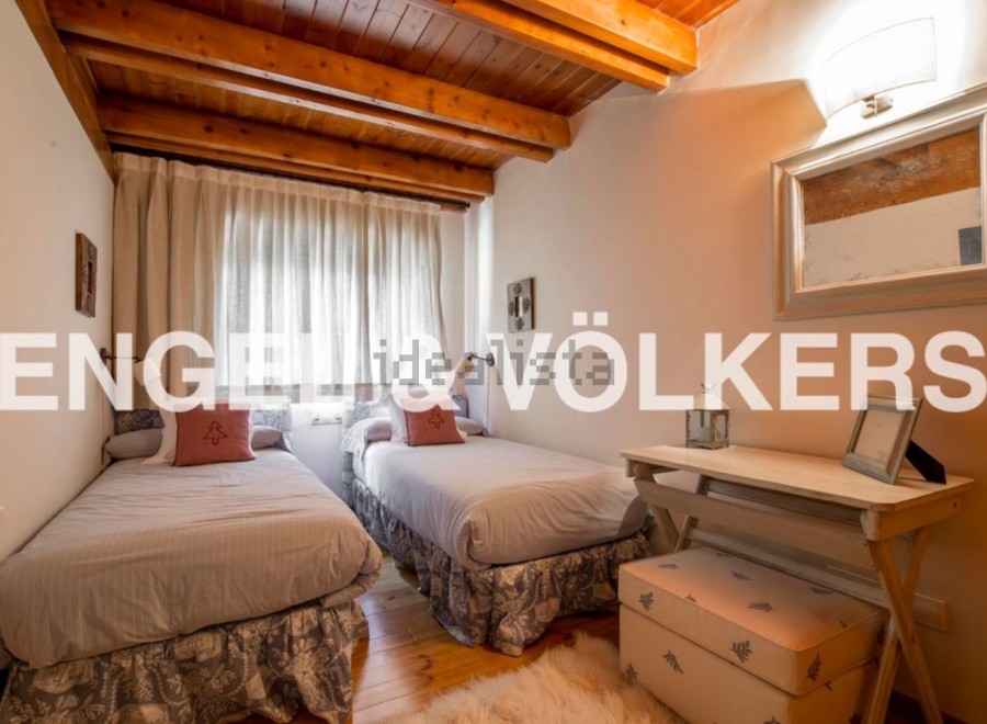 Charming bedroom with twin beds, wooden beams, and a cozy atmosphere.