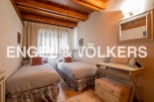 Charming bedroom with twin beds, wooden beams, and a cozy atmosphere.