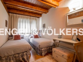 Charming bedroom with twin beds, wooden beams, and a cozy atmosphere.