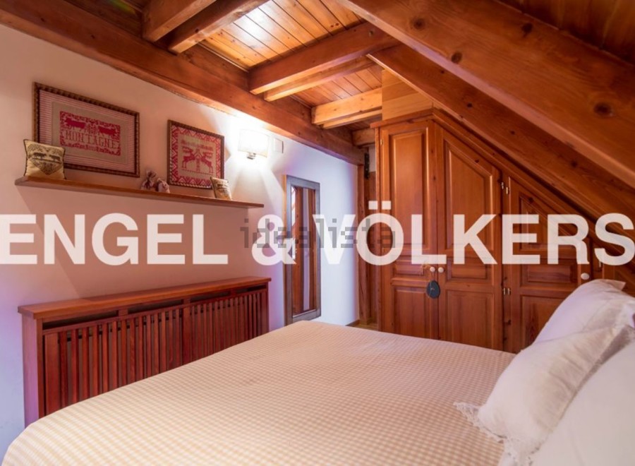 Charming attic bedroom with wooden beams and built-in wardrobe.