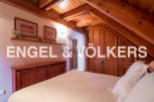 Charming attic bedroom with wooden beams and built-in wardrobe.