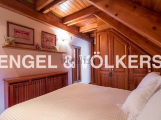 Charming attic bedroom with wooden beams and built-in wardrobe.