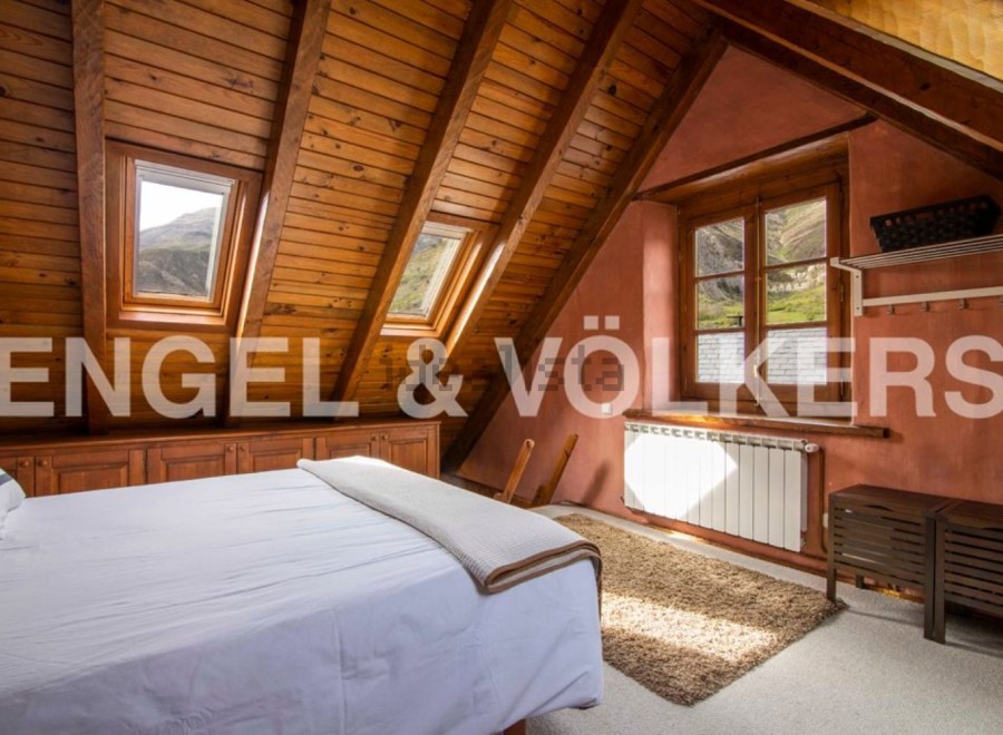 Cosy attic bedroom with wooden beams and mountain views.