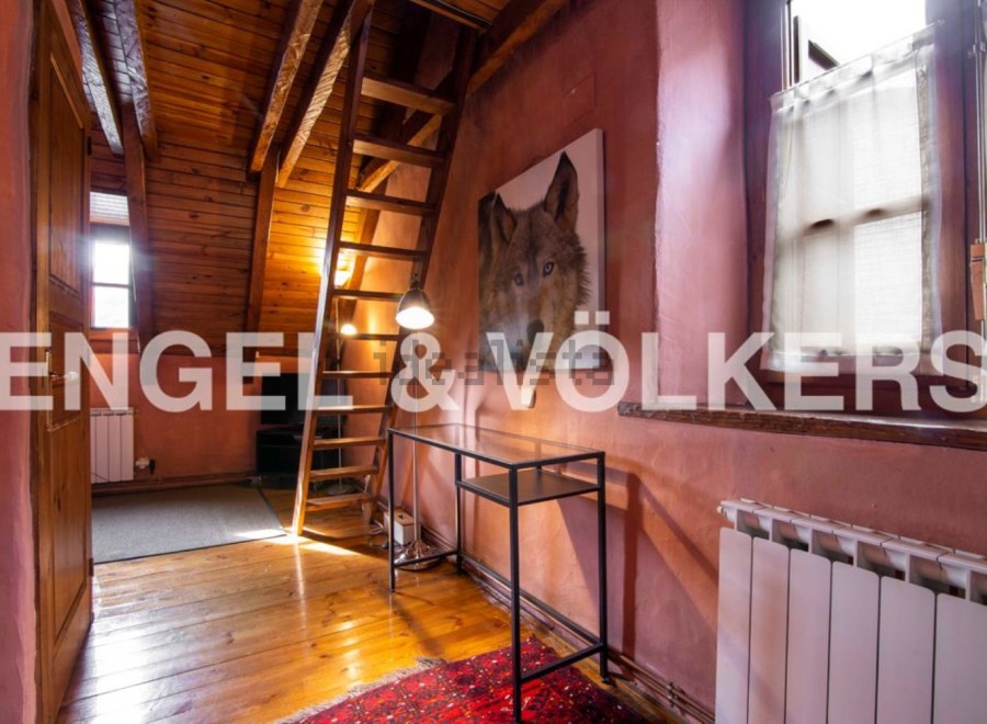Charming attic room with wooden beams, exposed brick walls, and a cozy atmosphere.