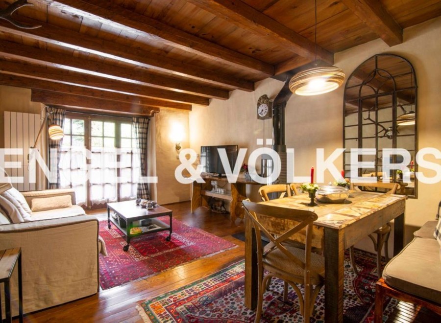 Charming rustic apartment with exposed wooden beams, a cozy living area, and a quaint dining space.