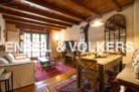Charming rustic apartment with exposed wooden beams, a cozy living area, and a quaint dining space.