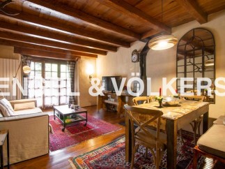 Charming rustic apartment with exposed wooden beams, a cozy living area, and a quaint dining space.