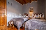 Charming rustic bedroom with twin beds, featuring wooden floors and beamed ceilings.