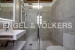 Modern bathroom with sleek, gray tile and a glass shower enclosure.