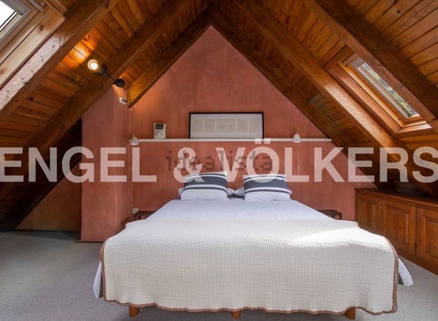 Charming attic bedroom with wooden beams and skylights.