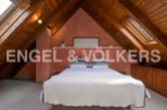 Charming attic bedroom with wooden beams and skylights.