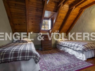 Charming attic bedroom with twin beds, wooden beams, and a cozy atmosphere.