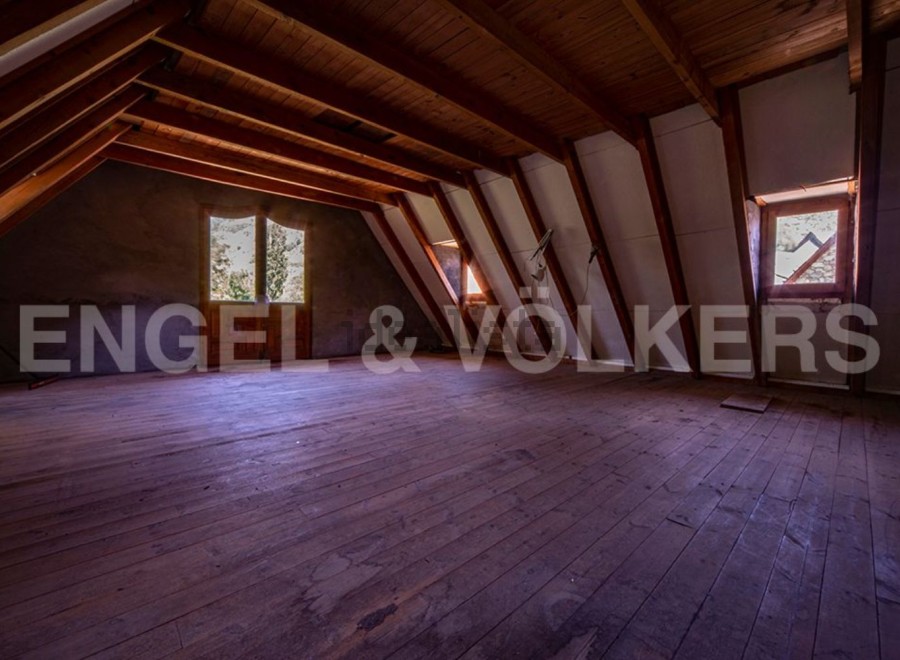 Discover this expansive attic space, boasting high ceilings and stunning wooden beams.