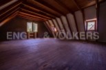 Discover this expansive attic space, boasting high ceilings and stunning wooden beams.