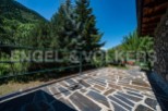 Mountain view balcony with stone tile flooring and metal railing.
