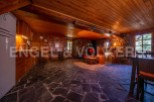 Rustic mountain cabin with stone and wood interior, featuring an open floor plan combining kitchen, living, and dining areas.
