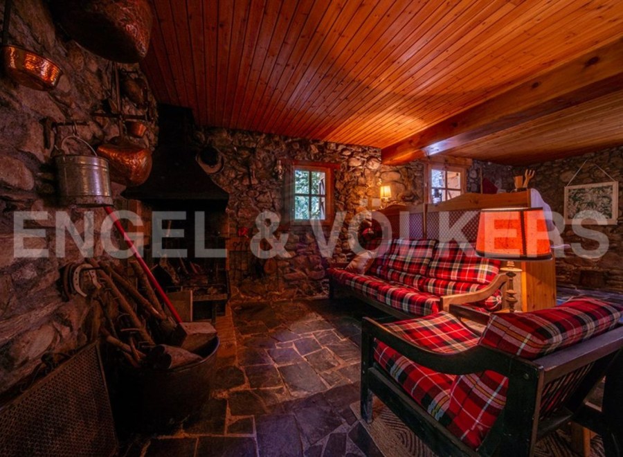 Rustic mountain retreat with stone walls and wood-beamed ceilings.