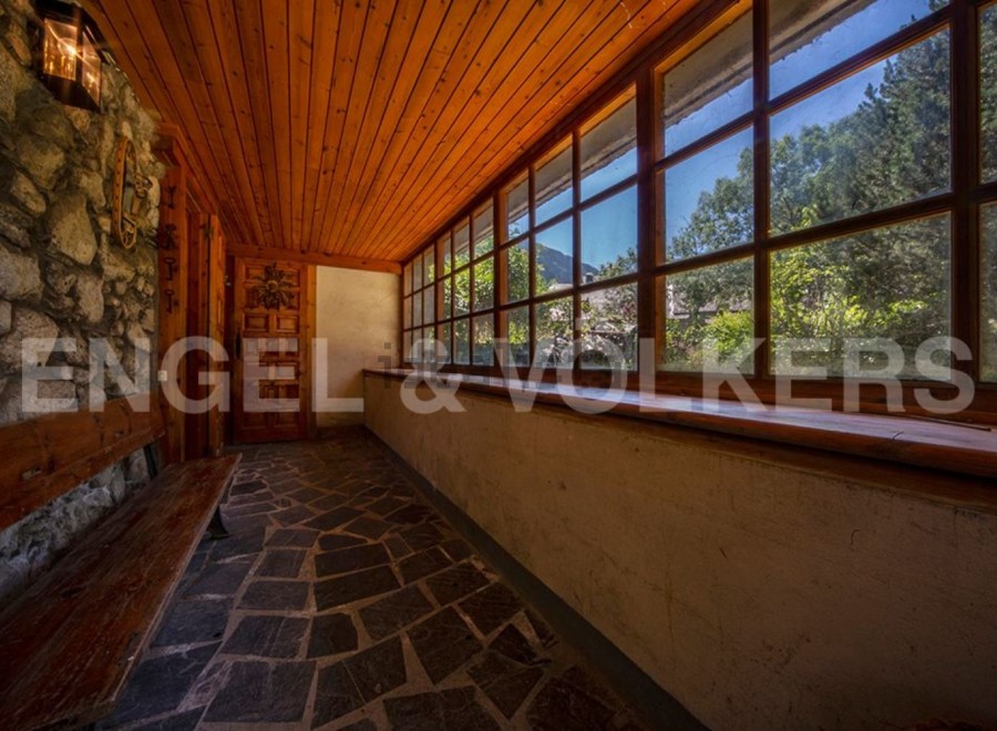 This charming property boasts a sun-drenched hallway with rustic stone walls and wooden flooring.