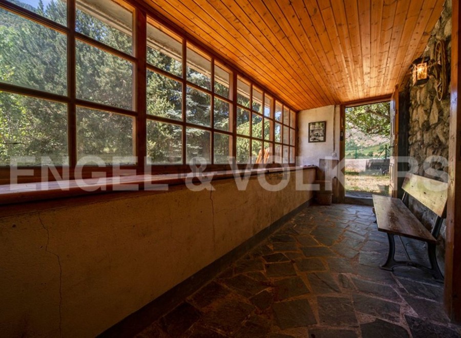 This charming property boasts a sun-drenched veranda with expansive windows offering breathtaking views of the surrounding landscape.