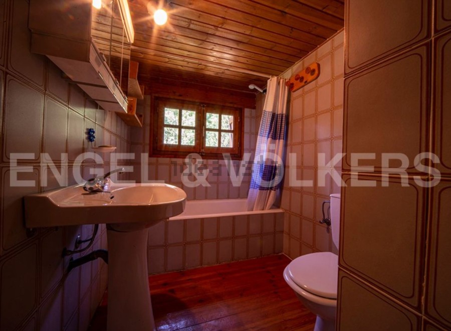 Cozy bathroom with wooden accents and tiled walls.