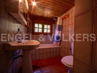 Cozy bathroom with wooden accents and tiled walls.