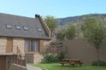 This charming stone house boasts a spacious layout with large windows and a private patio.