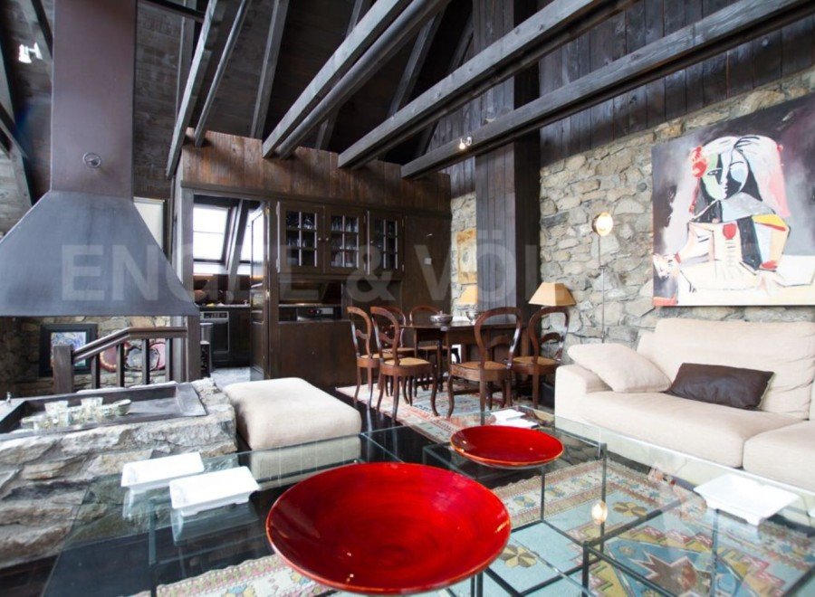 This stunning chalet boasts a spacious open-plan living area with a large stone fireplace, perfect for cozy nights in.