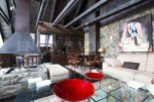 This stunning chalet boasts a spacious open-plan living area with a large stone fireplace, perfect for cozy nights in.