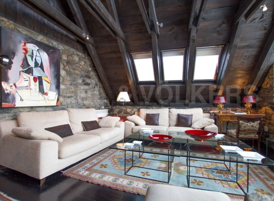 This stunning property boasts a spacious living area with exposed wooden beams and stone walls, creating a rustic yet elegant atmosphere.