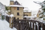 Charming stone house nestled in a snow-covered village, offering a picturesque winter escape.
