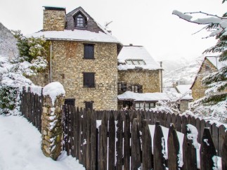 Charming stone house nestled in a snow-covered village, offering a picturesque winter escape.