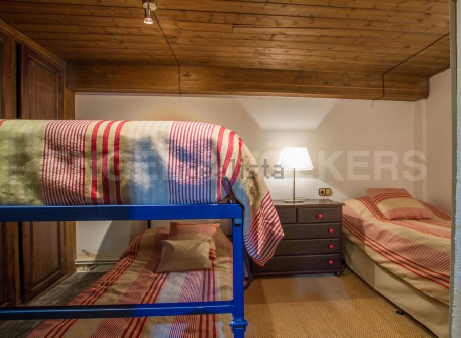 Charming attic bedroom with twin-size bunk beds and a single bed, perfect for families or groups.