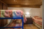 Charming attic bedroom with twin-size bunk beds and a single bed, perfect for families or groups.
