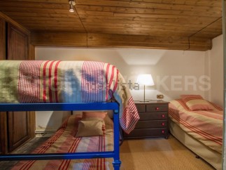 Charming attic bedroom with twin-size bunk beds and a single bed, perfect for families or groups.