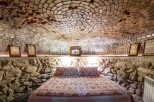 Unique cave-like bedroom with a stunning brick dome ceiling and stone walls.