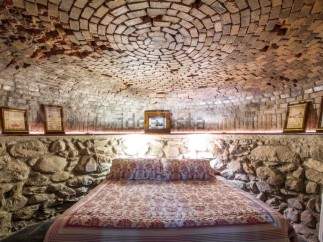 Unique cave-like bedroom with a stunning brick dome ceiling and stone walls.