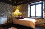 Cozy stone cottage bedroom with a single bed, featuring rustic charm and a warm, inviting atmosphere.