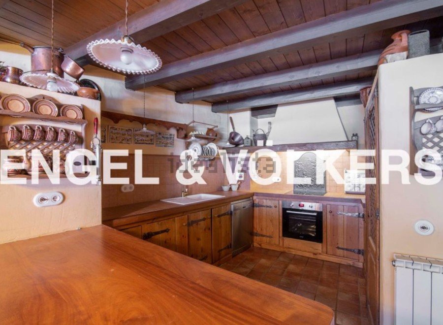 Rustic kitchen with wooden beams, exposed brick, and antique copper cookware.