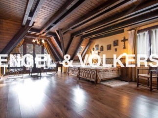 This stunning property boasts a spacious master bedroom with high wooden beamed ceilings and large windows offering abundant natural light.