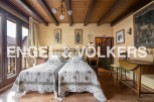 Charming rustic bedroom with twin beds, exposed wooden beams, and large windows offering mountain views.