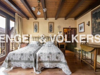 Charming rustic bedroom with twin beds, exposed wooden beams, and large windows offering mountain views.